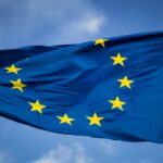 European Union flag waving against a blue sky.